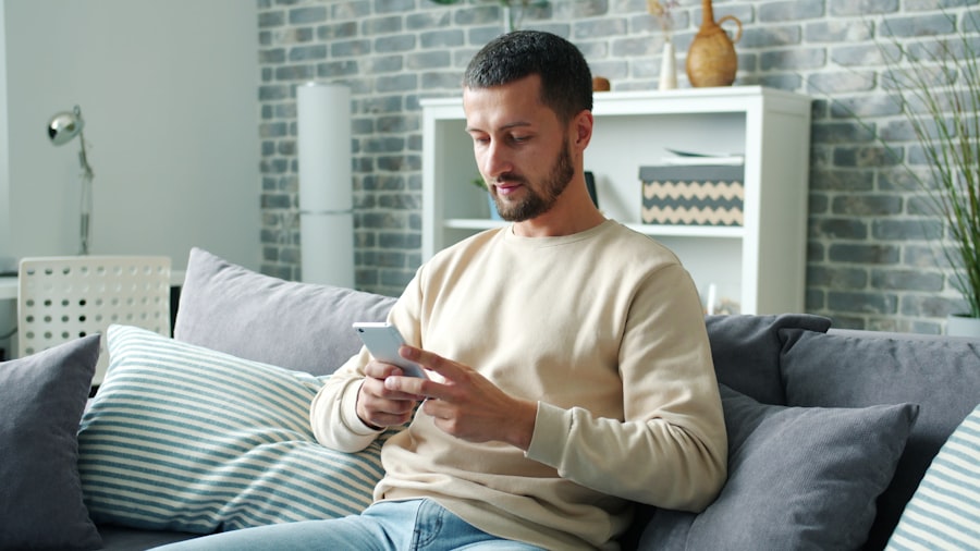 A man relaxing on his couch, checking his phone